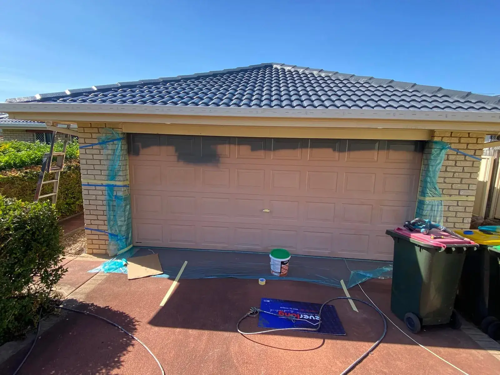 Garage door in Drewvale masked up, part way through painting