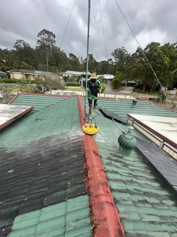 A clean stripe left by the surface cleaner across a dirty tile roof