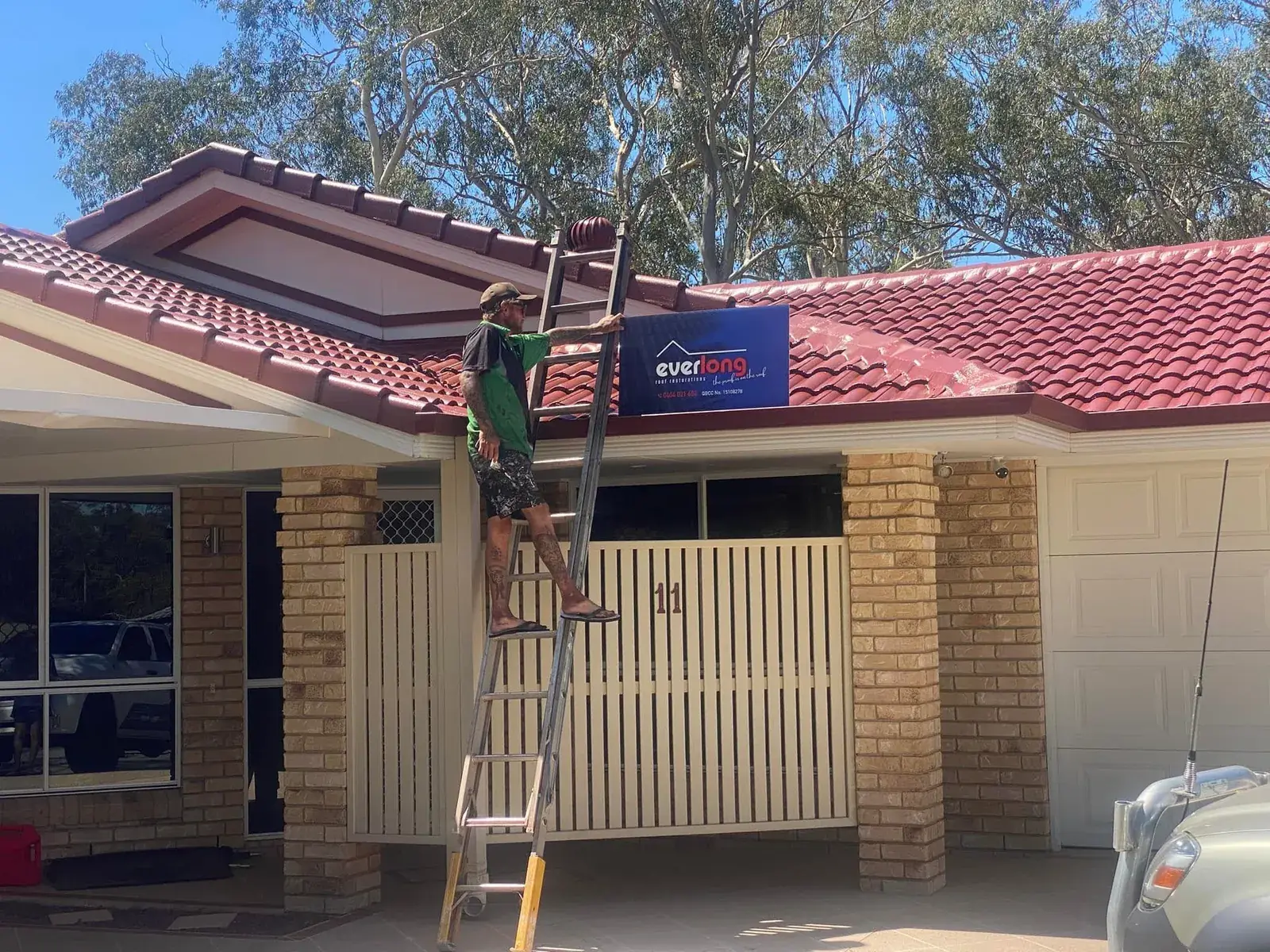 Working from a ladder at the gutter and fascia of a house