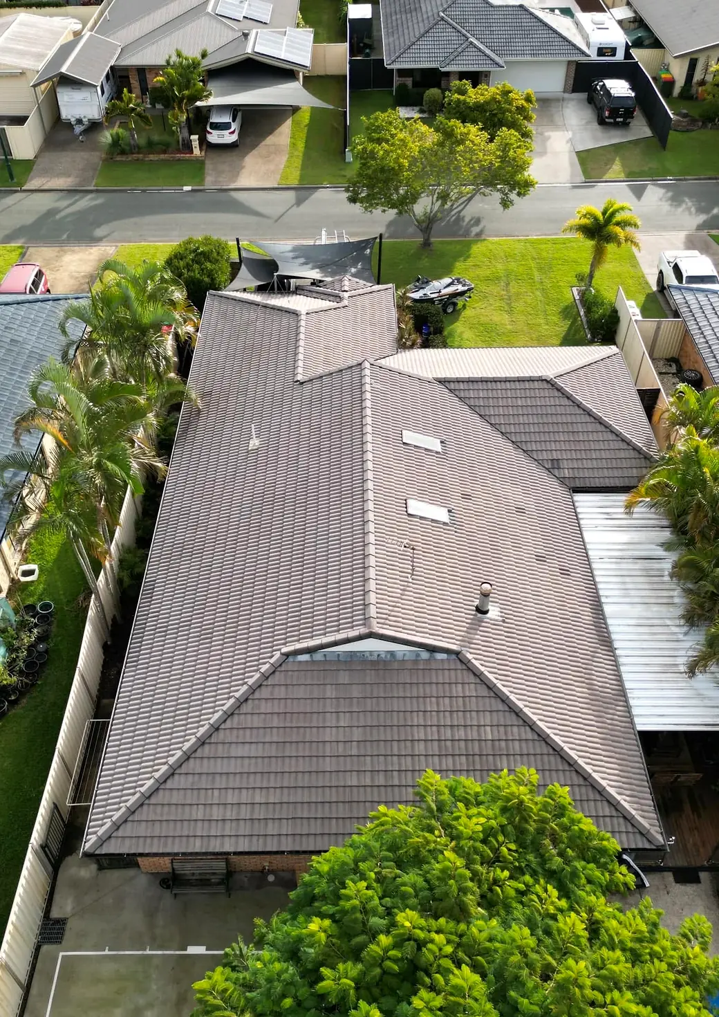 Drone view of a faded, patchy brown tile roof before restoration